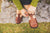 Woman buckling strap of Aurora Shoe Co. Brown T-Strap Handmade Leather Shoes.